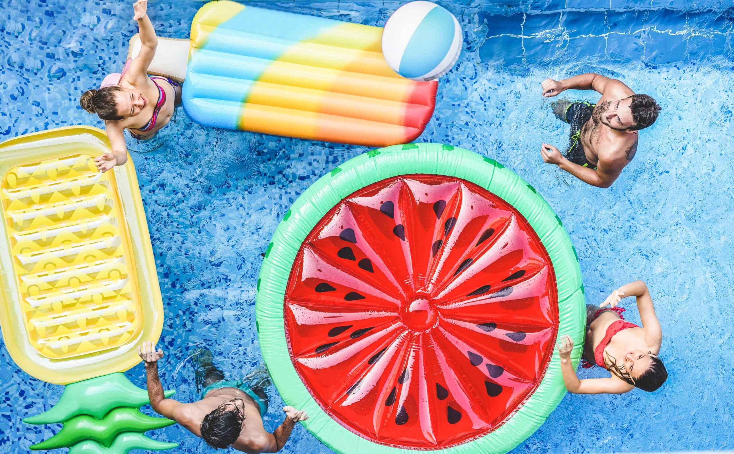 Happy friends playing with ball inside swimming pool - Young people having fun on summer holidays vacation - Travel